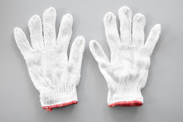 White cloth gloves on gray background.
