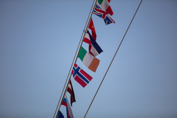 flags of different nationalities fluttering on the mast of the ship