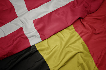 waving colorful flag of belgium and national flag of denmark.