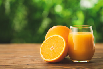 Glass of fresh orange juice on table outdoors