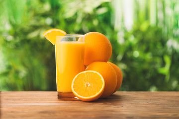 Glass of fresh orange juice on table outdoors