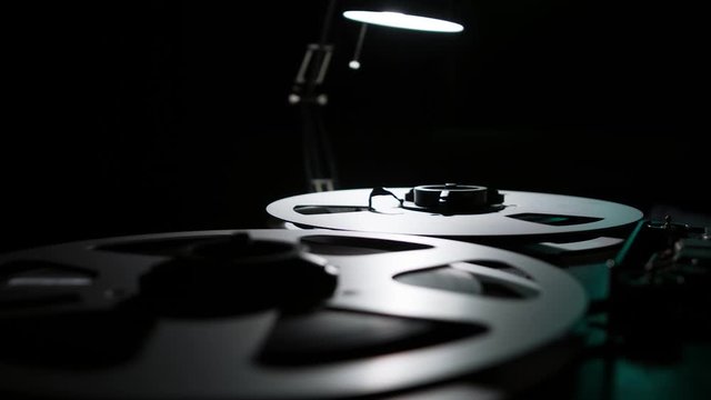  Retro Analog Quarter Inch Tape Recorder Being Operated in a Darkened Room