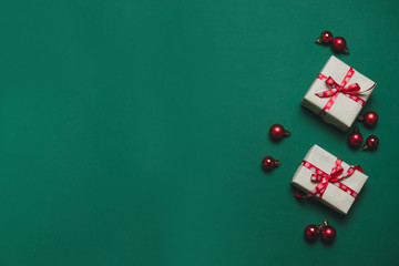 Creative composition with gifts or presents boxes with red bows, red balls on background. Flat lay style composition, top view.