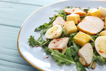 Plate with tasty salad on wooden background, closeup