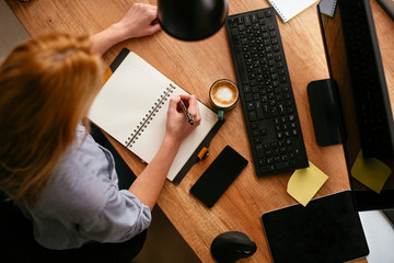 Close up of businesswoman taking notes in notebook