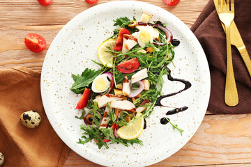 Plate with tasty salad on table