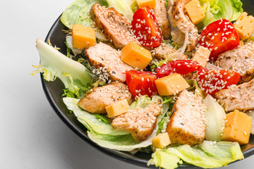Plate with tasty salad on light background, closeup