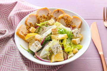 Plate with tasty salad on table