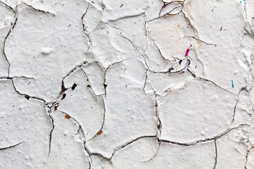 Surface texture with white paint and cracks on concrete wall. For abstract backgrounds.