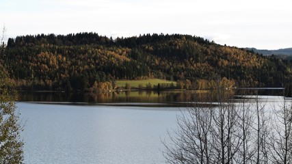 Autumn landscape of mountain and lake, with the colorful trees, symmetric reflection in the clean water