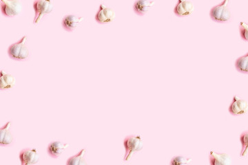 Flat lay composition with garlic on light pink background