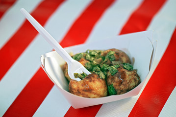 Portion of takoyaki over red and white striped tablecloth