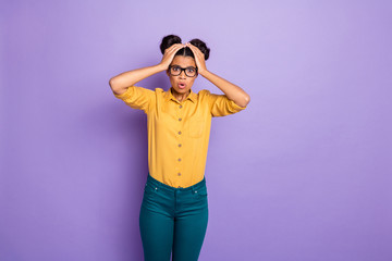 Photo of amazing pretty dark skin lady holding hands on head not believe awful news open mouth wear specs yellow shirt pants isolated purple color background