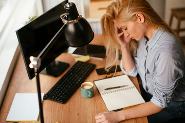Young businesswoman overworked. Tired woman having headache.