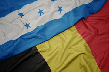 waving colorful flag of belgium and national flag of honduras.