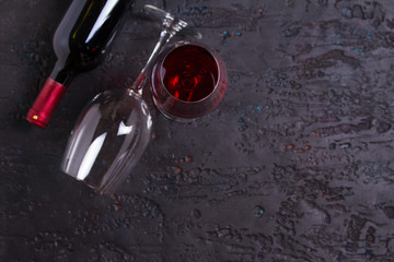Flat lay composition with bottle of wine and glasses on black background, copy space