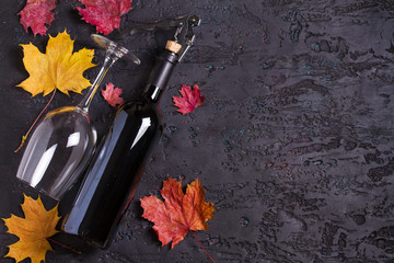 Flat lay composition with bottle of wine, glass and corkscrew on black background, copy space