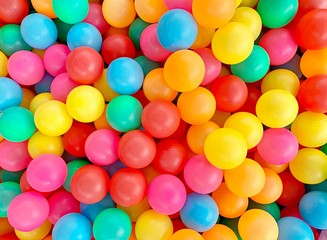 Many colorful plastic balls in a kids' ballpit at a playground, kind of toy for kids.