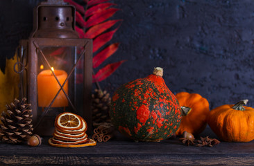 Autumn Thanksgiving decoration background with lantern, pumpkins, autumn leaves and pine cones. Copy space