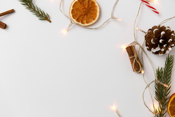 christmas, holidays and celebration concept - frame of garland lights and decorations on white background