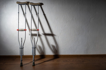 Crutches. People with limited mobility. Crutches against the wall. Damage to the legs. Leg injuries. Disability Rehabilitation upon receipt of an injury. Concept - accessible for disabled people.