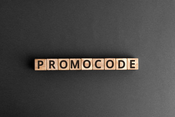 Promocode - word from wooden blocks with letters, coupon, promotion code, promo code concept,  top view on grey background