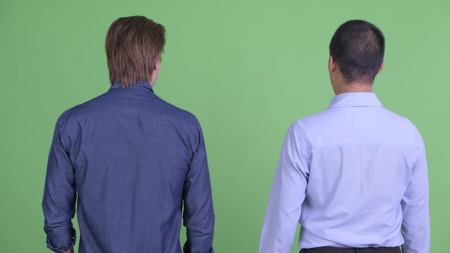 Two multi ethnic businessmen turning around and having conflict together