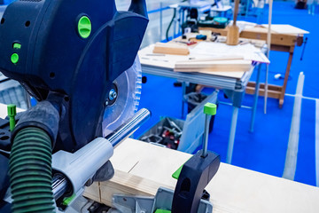 Stationary circular saw. Wood processing workshop. Circular saw in production. Wooden beams. Wood processing. Furniture shop. Tools for the furniture workshop. Work with a stationary circular saw.