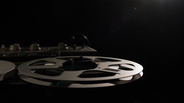  Retro Analog Quarter Inch Tape Recorder Being Operated in a Darkened Room