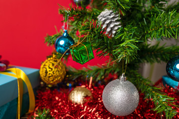 The main symbol of the New Year is a Christmas tree decorated with bright Christmas toys, under which there are many bright gifts. Close-up. The atmosphere of magic and happiness. New Year's Eve.