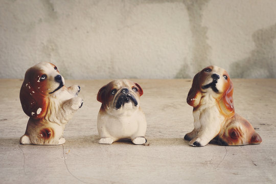 Doll, three dogs made of ceramic on wood floors.