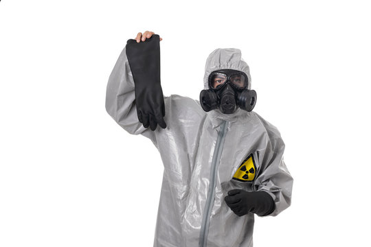 A man poses in a protective suit, with a gas mask, posing while standing on a white background and holding a protective glove in his hand. Ecology protection concept. radiation. We save nature 