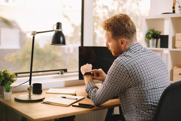 Young man looking at his watch 