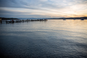 Fototapeta na wymiar Steg in Percha am Starnberger See am Abend mit Bergblick