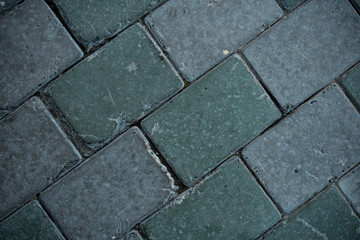 Texture of paving slabs overgrown with grass. Background image of a stratum stone