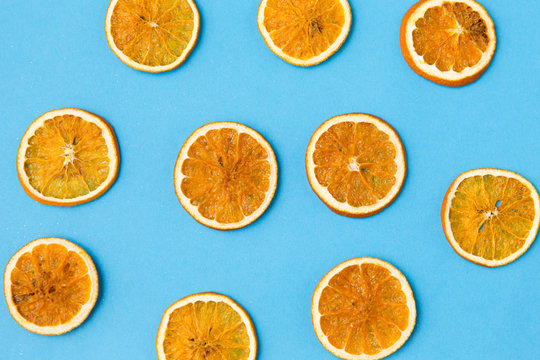 christmad, winter and citrus concept - dried orange slices on blue background