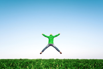 Man jump on amazing meadow in summer field. Success and happiness concept