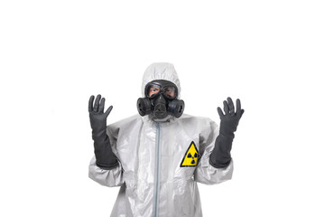 A man poses in a gray protective suit, with a protective gas mask, posing while standing on a white...