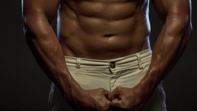 Fitness tanned guy showing muscles, close up