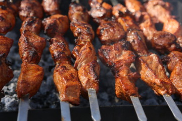 Mixed grilled meat platter. Assorted delicious grilled meat. The closeup of some meat skewers being grilled in a barbecue. grilled meat skewers, barbecue.