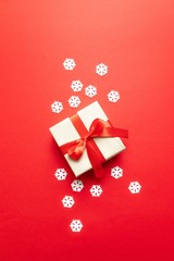 Festive christmas composition with snowflakes and gift box on red background. Winter concept. Flat lay, top view, copy space
