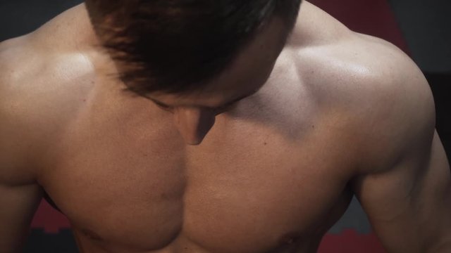 Fitness tanned guy showing muscles, close up