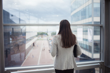 Fototapeta premium Young businesswoman talking on the phone, business communication. In the office or business center.