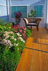 Achillea varities in an enclosed flower border with a seat and decking © Garden Guru
