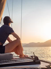 Stoff pro Meter attractive young woman in a striped t-shirt enjoys the sunset on the deck of a sailing yacht. Sailing regatta © Alexander