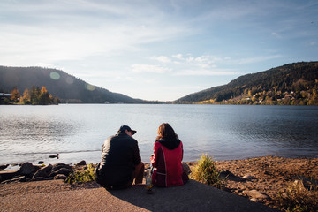 un couple d'amoureux devant le lac de Gérardmer. Des gens assis devant un lac. Des amoureux...