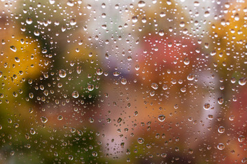 Raindrops on a window. Colorful autumn abstract background in soft colors. moody rainy weather