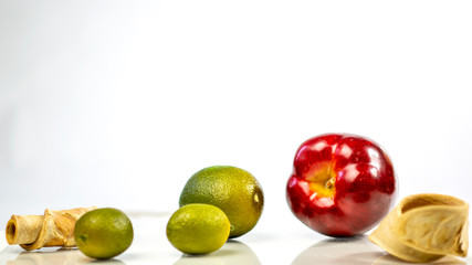 fresh green lemon and apples on white background