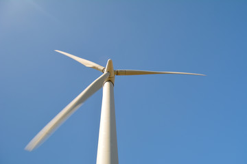 Close-up and low angle view of spinning blades of a wind turbine