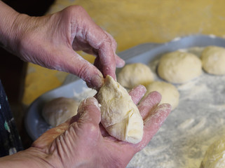 Grandmother baker hands making pie from dough.